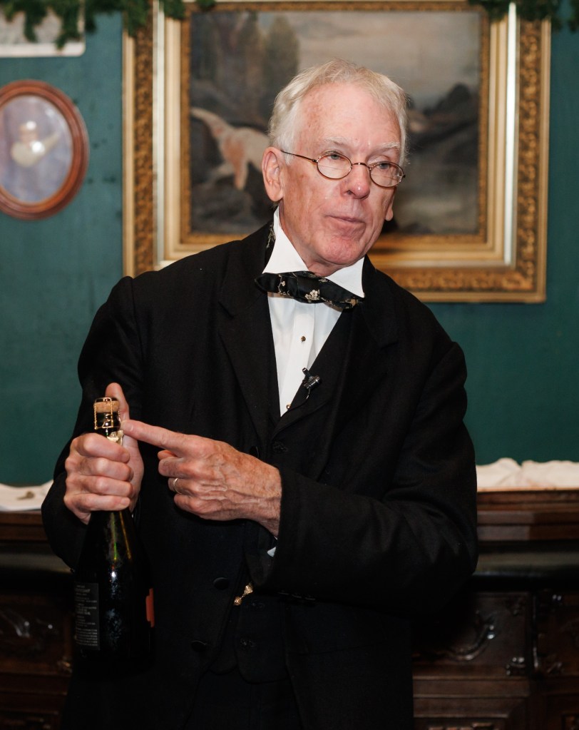 Mr. Embleton prepares to remove the muselet from a bottle of Champagne.